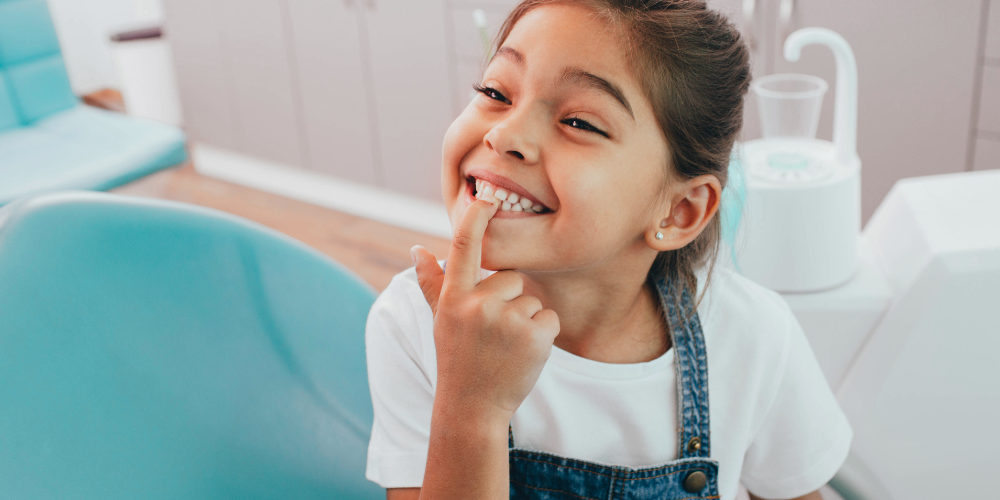 child patient showing her teeth to a dentist