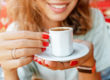 Woman drinking a cup of coffee whilst smiling and enjoying her day.
