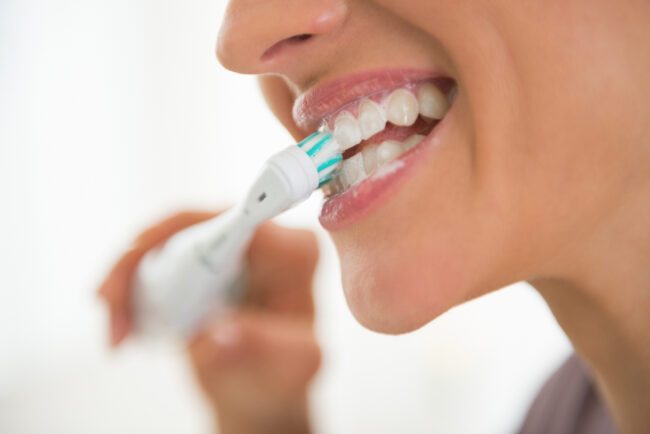 can-poor-dental-hygiene-make-you-sick Woman brushing teeth to prevent illness and tooth decay.