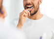 man with toothbrush cleaning teeth