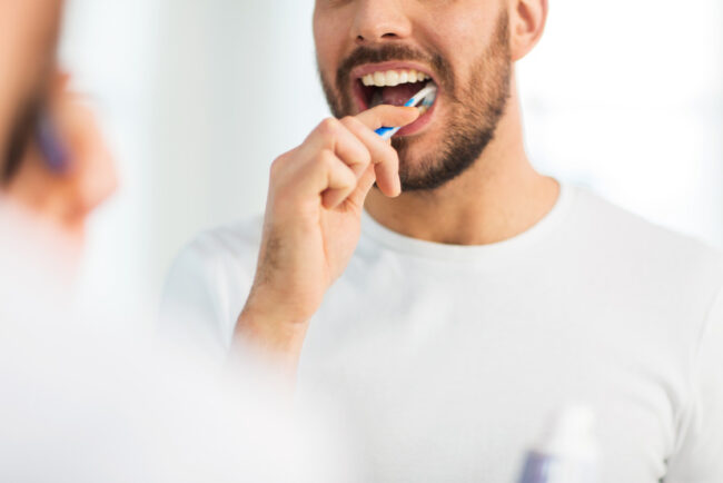 man with toothbrush cleaning teeth
