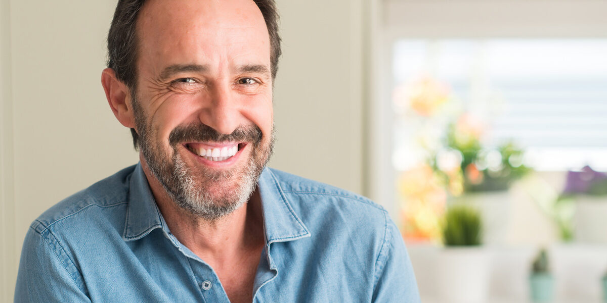 Handsome middle age man with a happy face standing and smiling with a confident smile showing teeth