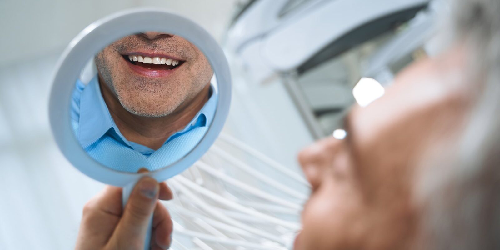Dental patient smiling confidently after successful implant treatment supported by bone grafting