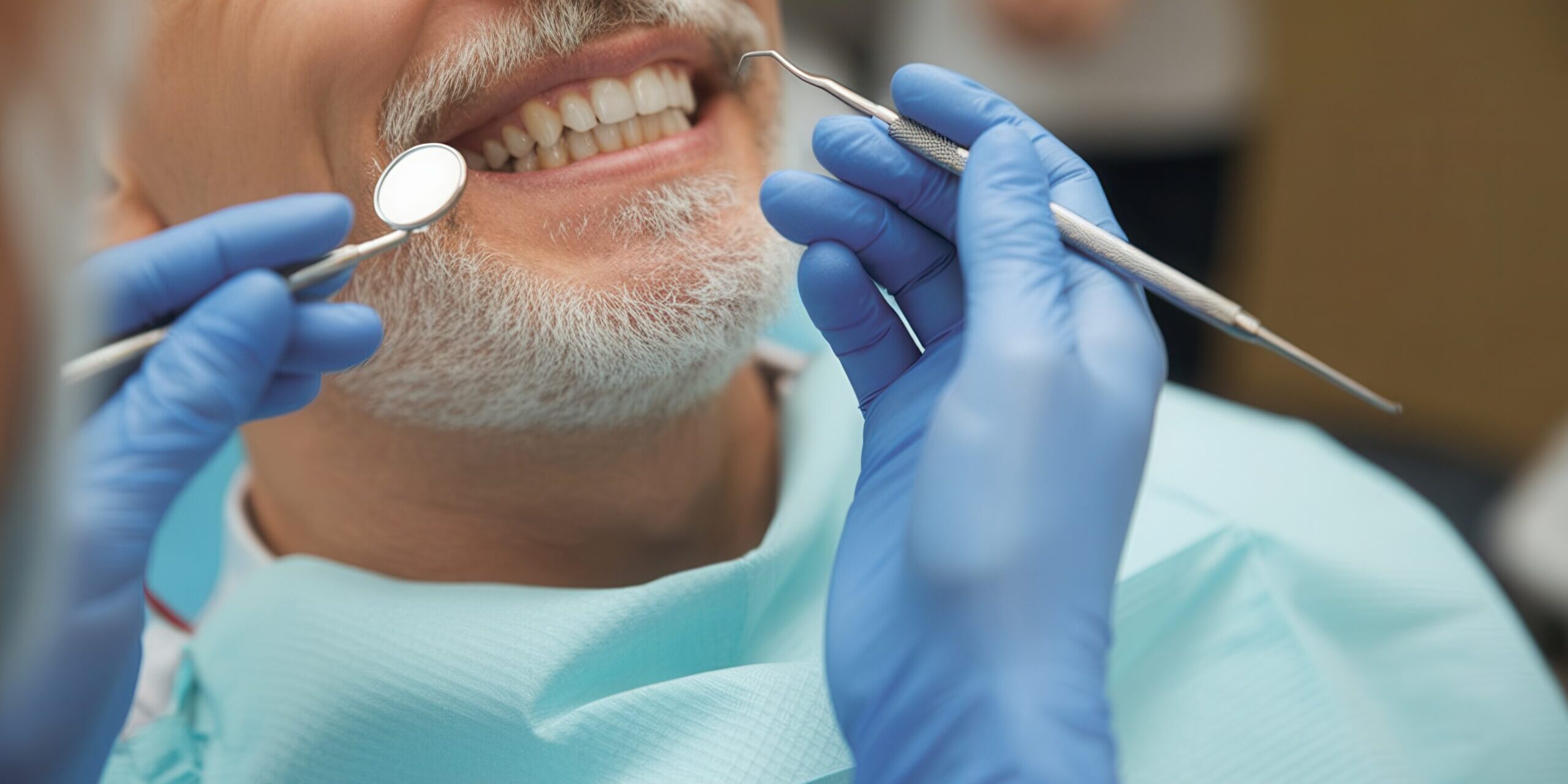 Smiling senior man with beard having a dental checkup with mirror and probe in a modern clinic Smiling senior man with beard having a dental checkup with mirror and probe in a modern clinic